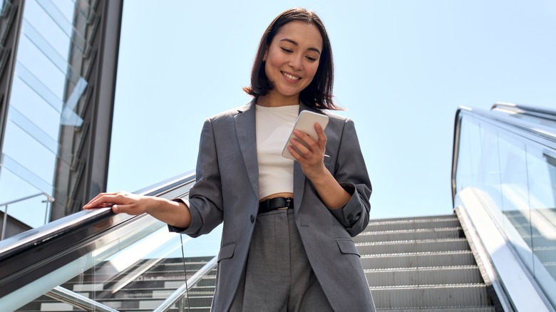 A woman smiles at her phone