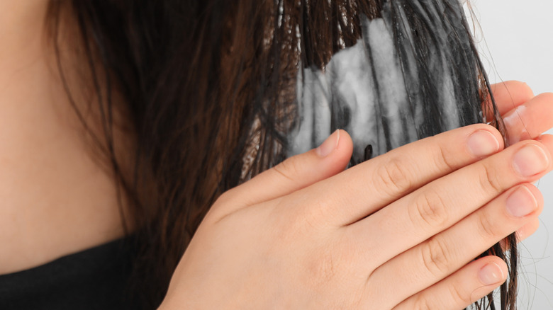 A woman applying hair conditioner in the bathroom