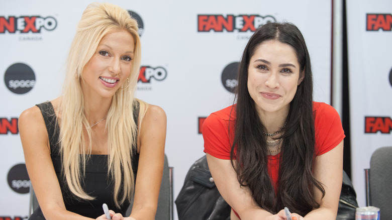 Miriam McDonald smiles next to Cassie Steele in a red shirt.