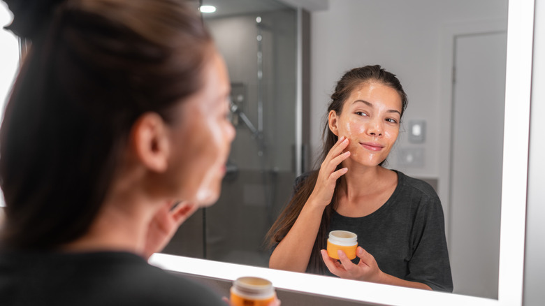 Woman applying skincare to face