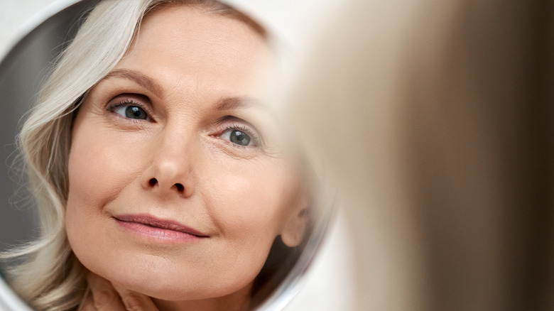 A middle-aged woman looking in the mirror 