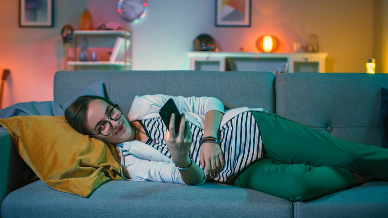 Woman texting on couch 