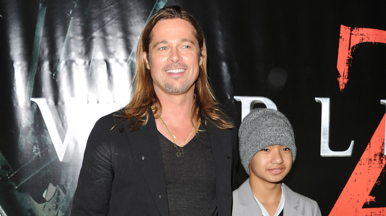 Brad Pitt posing with Maddox on the red carpet