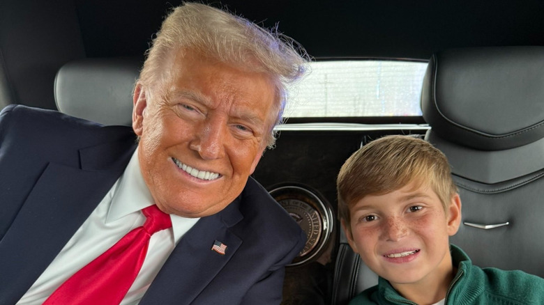 President Donald Trump sits in a limo with grandson Theodore Kushner