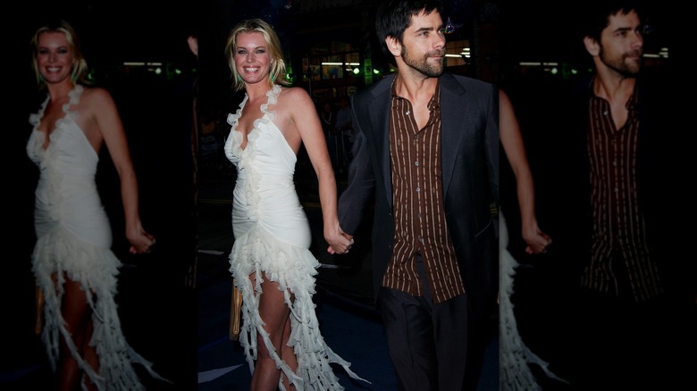 Rebecca Romijn in white dress holding hands with John Stamos