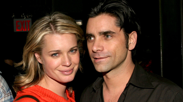 Close up of Rebecca Romijn smiling and John Stamos