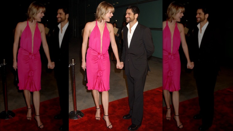 Rebecca Romijn in pink dress holding hands with John Stamos