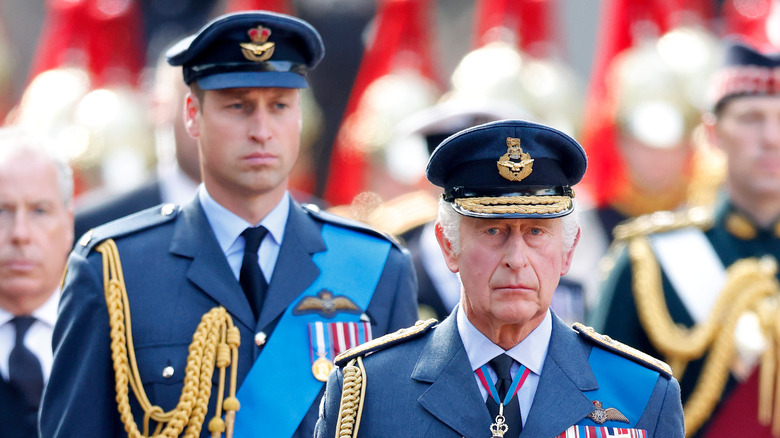 Prince William walking behind King Charles