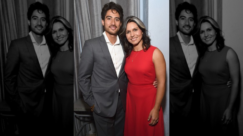 Tulsi Gabbard in a red dress with husband Abraham William in a grey suit