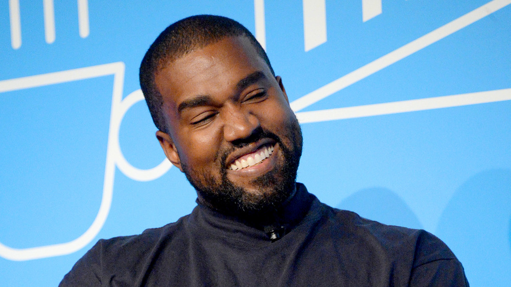 Kanye West smiling, squinting