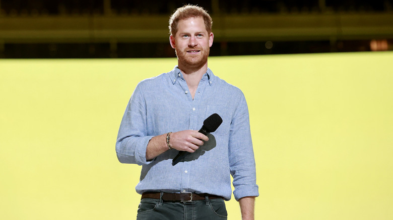 Prince Harry holding a mircophone 