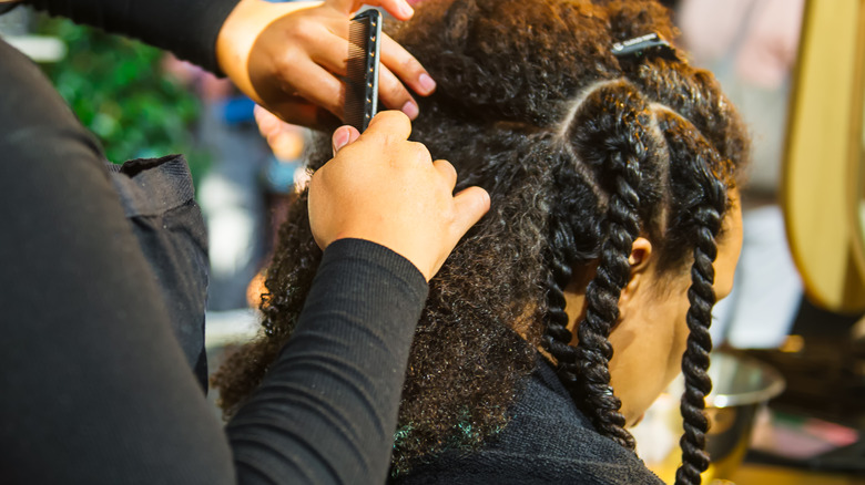 stylist twisting black woman's hair