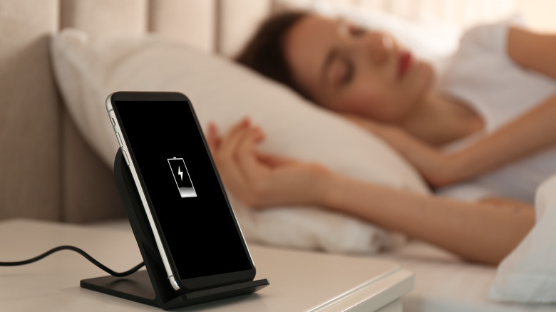 Phone charges on nightstand while person sleeps