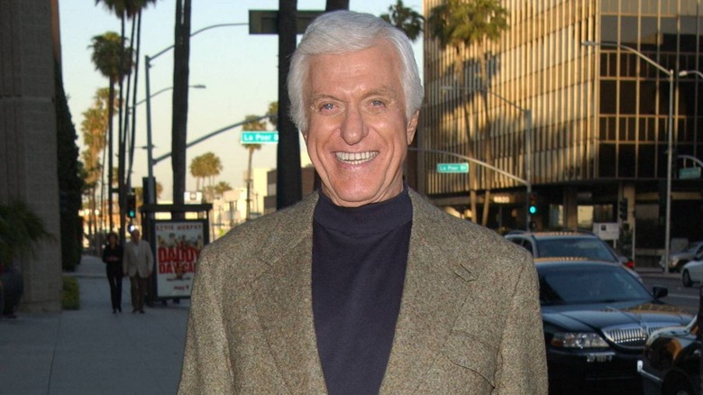 Dick Van Dyke smiling while on a city sidewalk