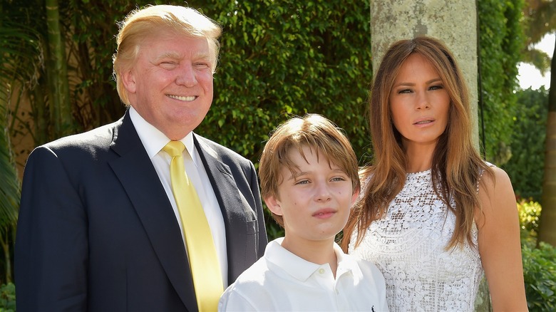 Donald, Barron, and Melania Trump posing at The Mar-a-Largo Club in 2015