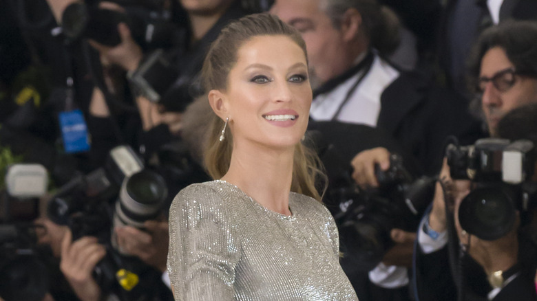 Gisele Bündchen smiling in silver dress