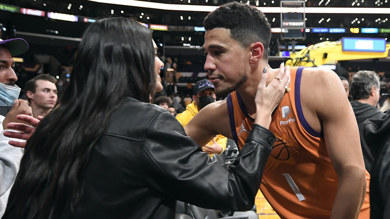 Kendall Jenner and Devin Booker embracing courtside