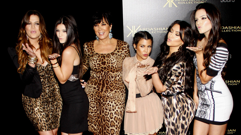 Khloe, Kourtney, and Kim Kardashian posing with Kylie, Kris and Kendall Jenner at an event