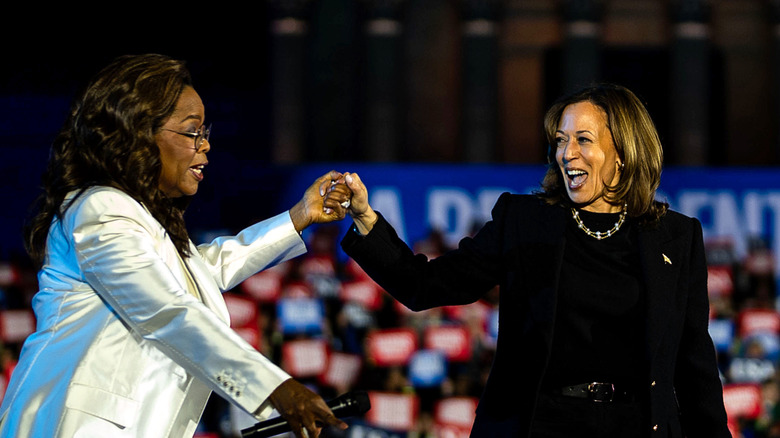 Oprah Winfrey holding Kamala Harris' hand