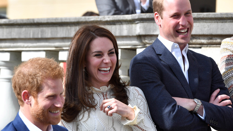 Princes William and Harry laugh with Kate Middleton. 