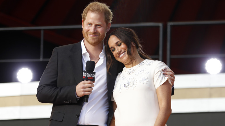 Meghan Markle cuddles up to Prince Harry onstage