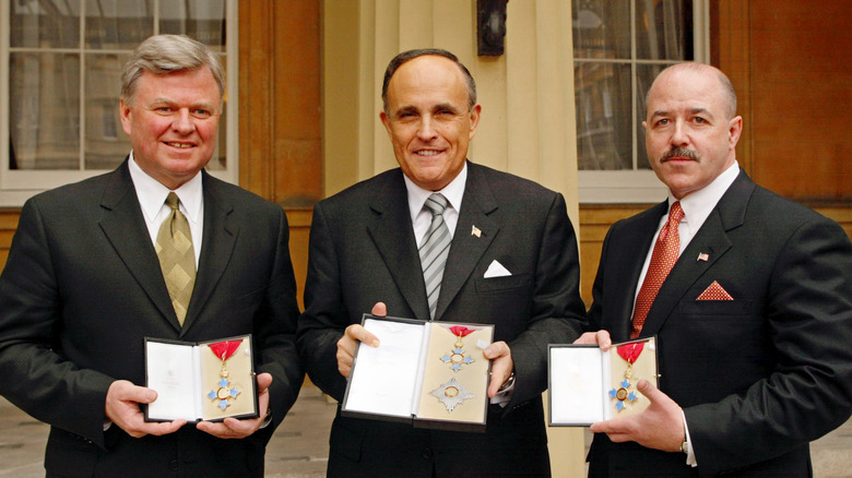 former New York Mayor Rudolph Giuliani (C) with his Knighthood of the British Empire (KBE) medal