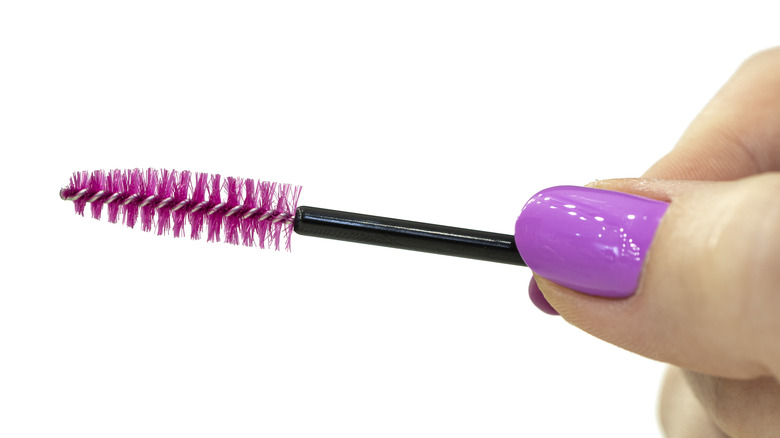 Miniature mascara wand in hand