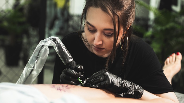 woman tattooing person