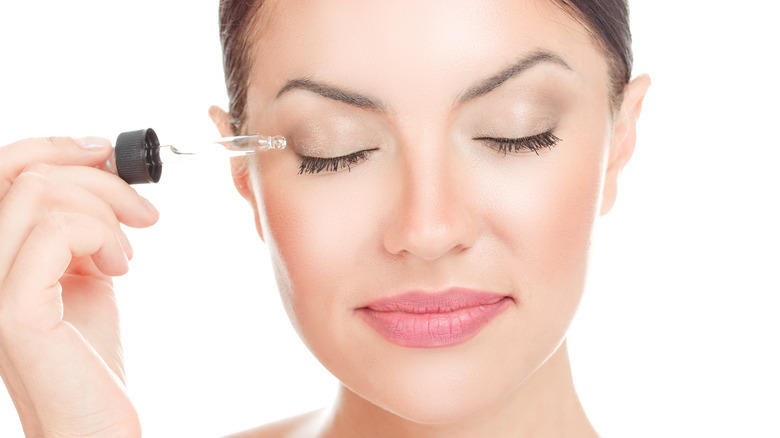 woman applying eyelash serum