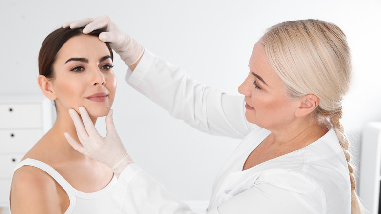 A doctor consults with a woman over her skin issues