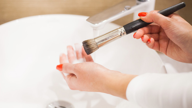 woman cleaning makeup brushes