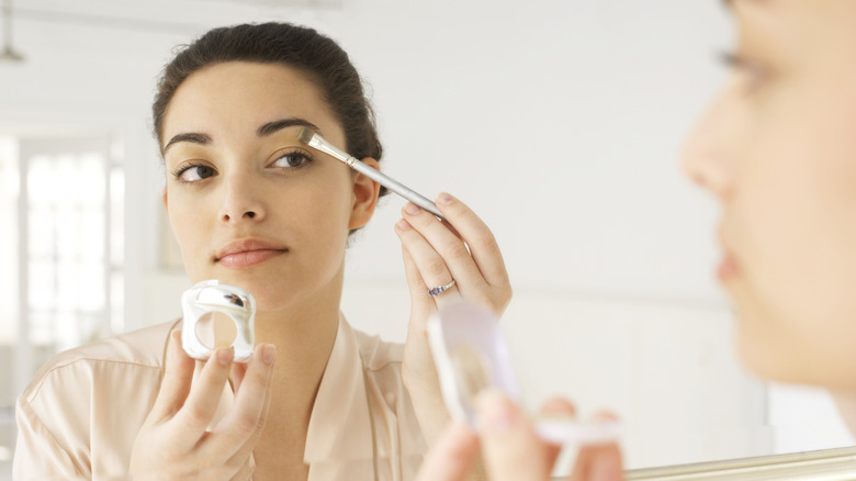 Woman using makeup brush