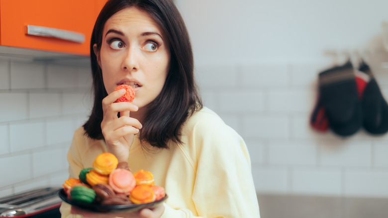 A woman eating macarons 