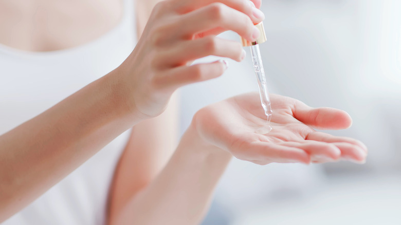 Woman putting oil onto hand