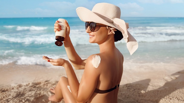 Woman applying sunscreen on beach