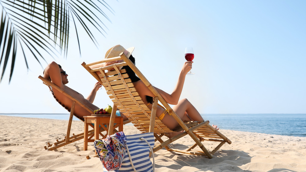 A woman drinking wine on the beach