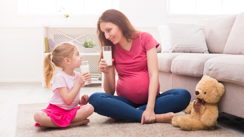 pregnant person and a child drinking milk