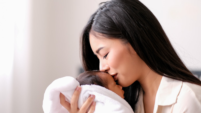 Mother kissing baby with hair