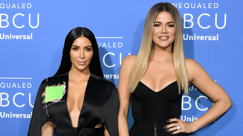 Kim Kardashian and Khloé Kardashian posing on red carpet