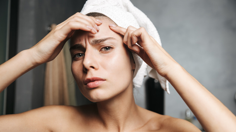 woman examining her face