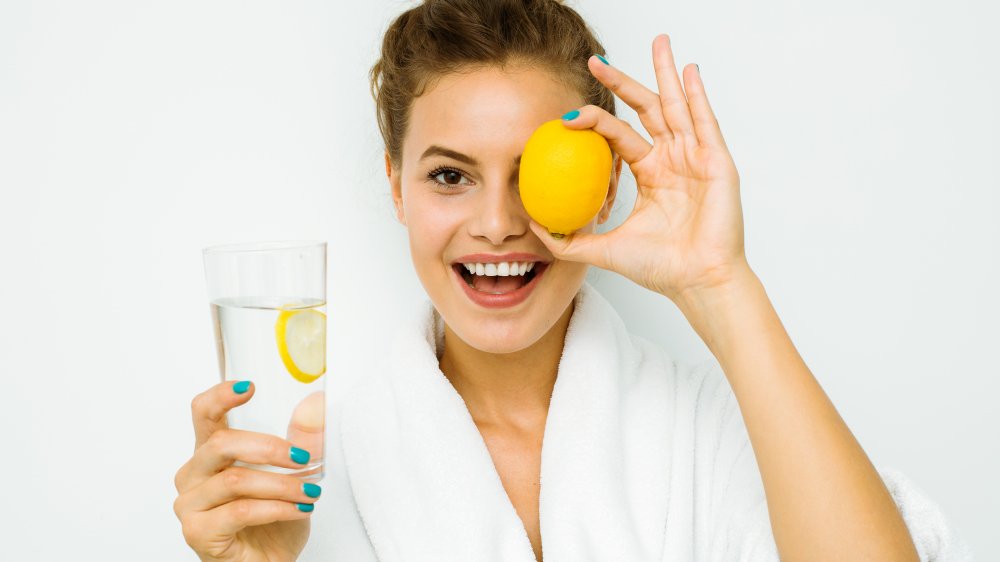 Woman with a lemon and lemon water