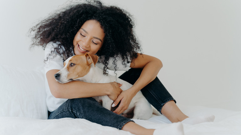 Woman cuddling dog