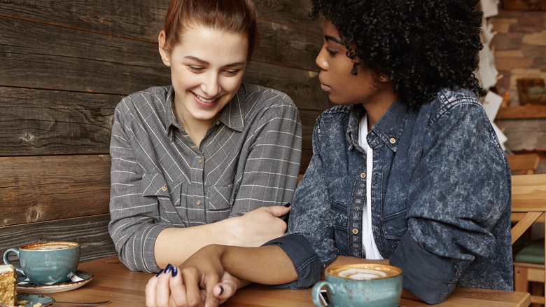 Gay couple holding hands over coffee