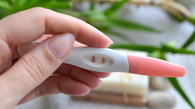 Person holding a pregnancy test strip