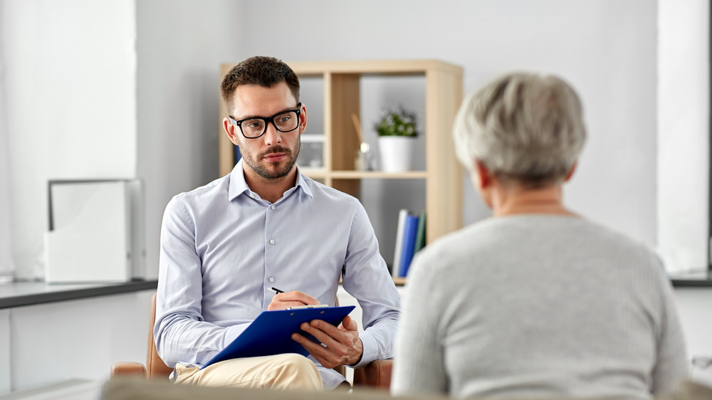 Therapist taking notes with clients