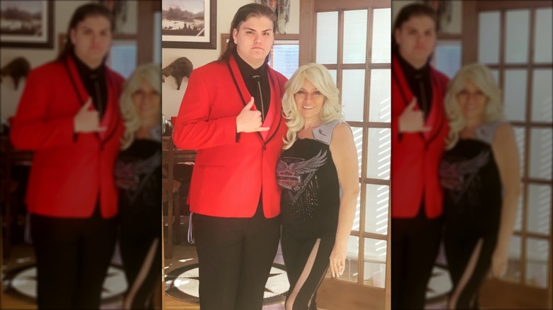 Garry Chapman standing in a red suit next to his mom, Beth Chapman.