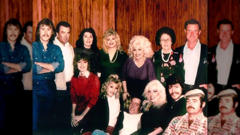 Dolly Parton smiling, pictured with her many siblings