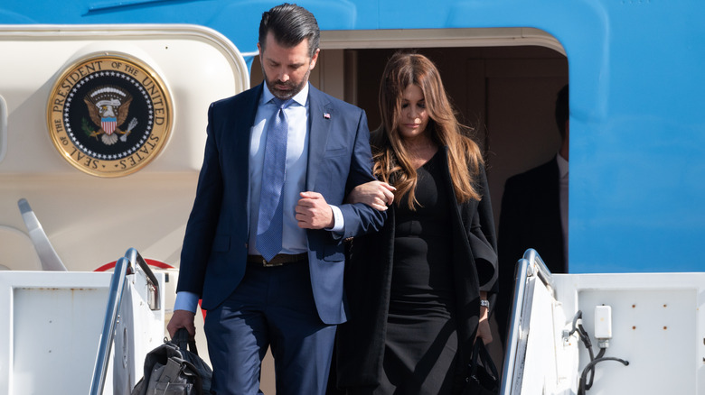 Donald Trump Jr. and Kimberly Guilfoyle lock arms leaving Air Force One