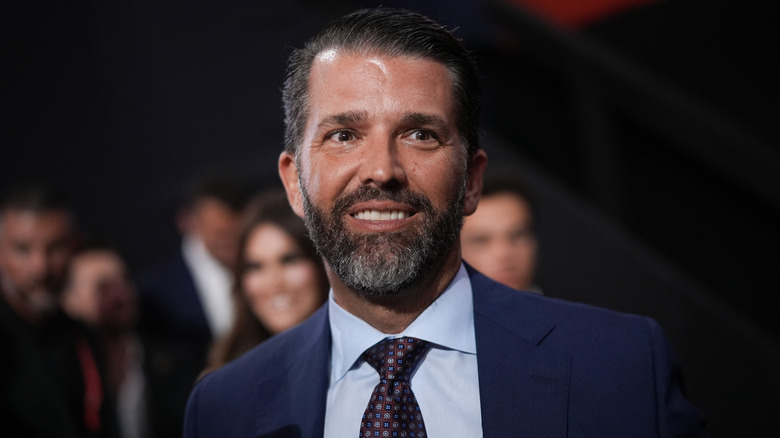 Donald Trump Jr. smiling in a suit at the RNC