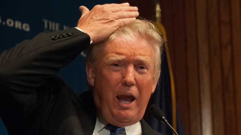 Donald Trump showing a crowd his hair during a speech